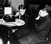 Boys listen to an early radio manufactured by Westinghouse in 1921.